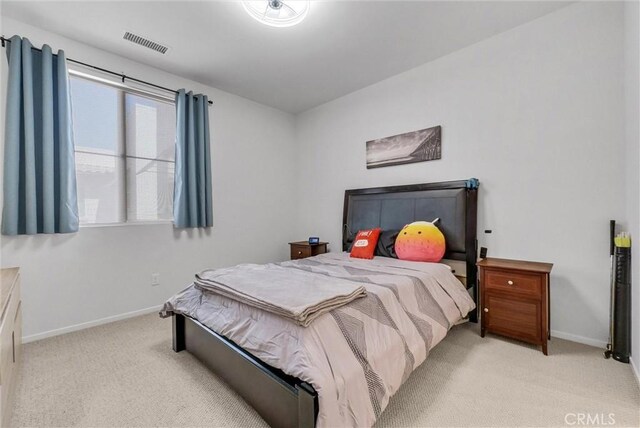 bedroom featuring light carpet and baseboards