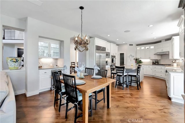 6288 Sunnyside Cir, Huntington Beach, CA 92648 - dining space with visible vents, baseboards, an inviting chandelier, recessed lighting, and wood finished floors