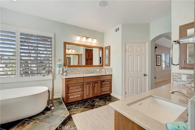 6288 Sunnyside Cir, Huntington Beach, CA 92648 - bathroom with a soaking tub, vanity, visible vents, baseboards, and backsplash