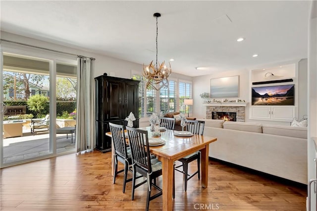 6288 Sunnyside Cir, Huntington Beach, CA 92648 - dining area with recessed lighting, a notable chandelier, a stone fireplace, and wood finished floors