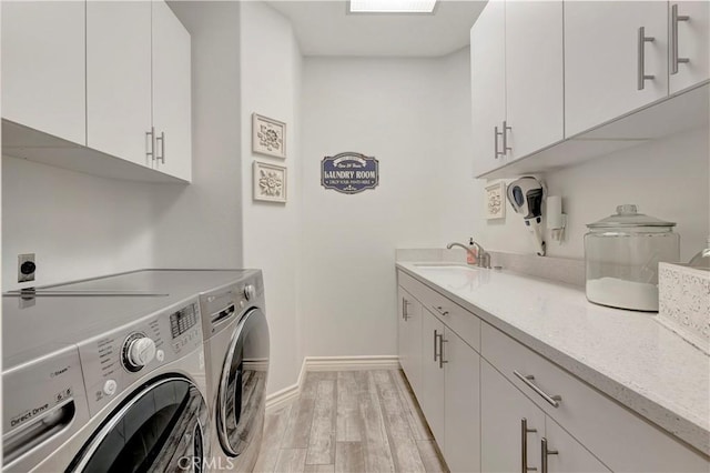 6288 Sunnyside Cir, Huntington Beach, CA 92648 - laundry room with light wood-style flooring, separate washer and dryer, a sink, baseboards, and cabinet space