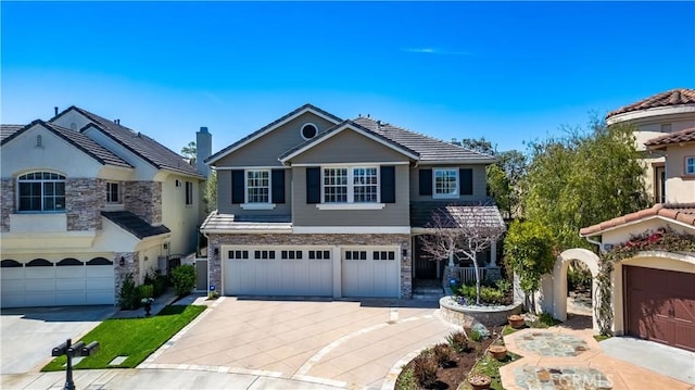 6288 Sunnyside Cir, Huntington Beach, CA 92648 - view of front of house with a tile roof, driveway, stone siding, and a garage