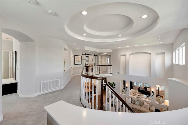 6288 Sunnyside Cir, Huntington Beach, CA 92648 - corridor with visible vents, a raised ceiling, arched walkways, an upstairs landing, and recessed lighting