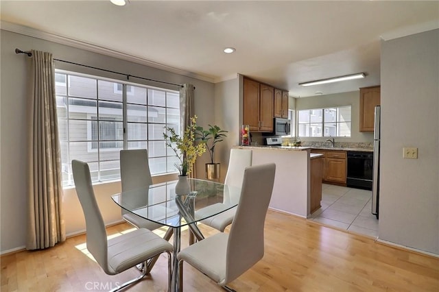 dining room with crown molding, light wood finished floors, and recessed lighting