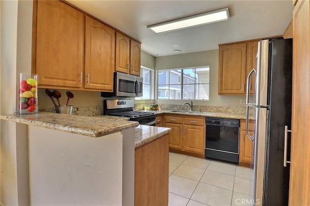 kitchen with light stone counters, light tile patterned floors, a sink, a peninsula, and appliances with stainless steel finishes