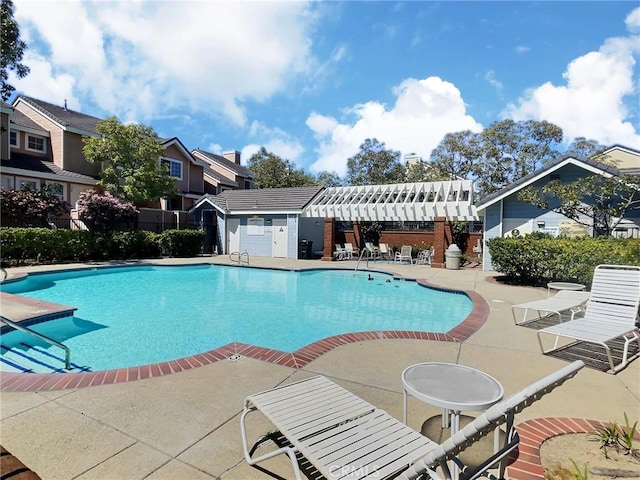 community pool with fence, a residential view, and a patio
