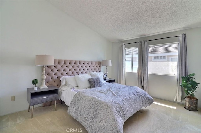 bedroom with vaulted ceiling, carpet flooring, and a textured ceiling