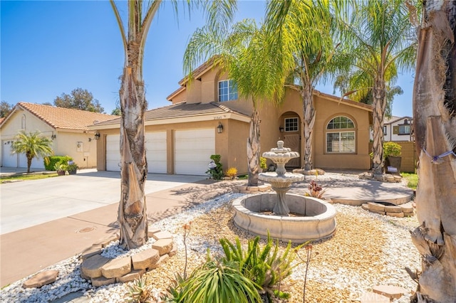 mediterranean / spanish-style home featuring concrete driveway, stucco siding, and a tiled roof