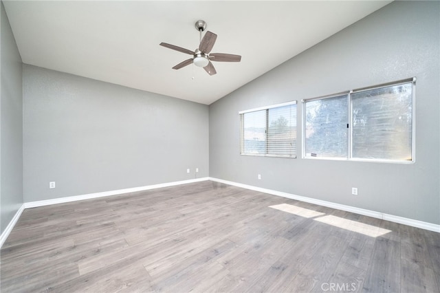 unfurnished room featuring ceiling fan, baseboards, wood finished floors, and lofted ceiling