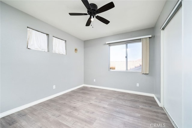 unfurnished bedroom with a closet, ceiling fan, baseboards, and wood finished floors