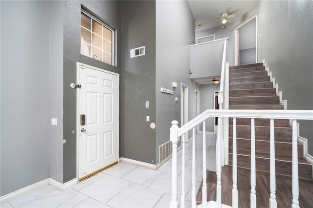 entrance foyer with stairway, visible vents, marble finish floor, and baseboards