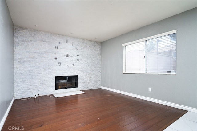 unfurnished living room with a fireplace, baseboards, and hardwood / wood-style flooring