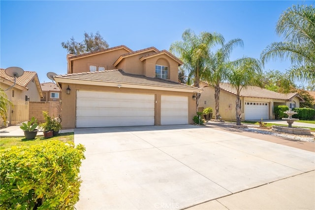 view of front of home with a tiled roof, a garage, concrete driveway, fence, and stucco siding