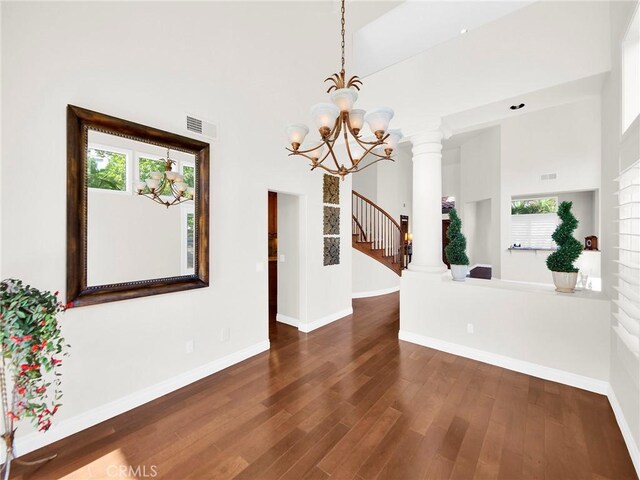 125 Heath Meadow Pl, Simi Valley, CA 93065 - unfurnished room with a high ceiling, a chandelier, healthy amount of natural light, dark wood finished floors, and stairs