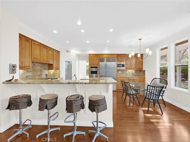 125 Heath Meadow Pl, Simi Valley, CA 93065 - kitchen with built in appliances, recessed lighting, a breakfast bar area, decorative backsplash, and a peninsula