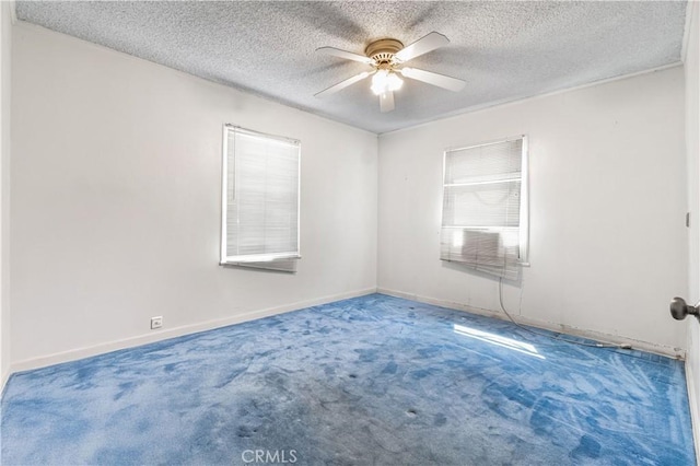 unfurnished room with a textured ceiling, baseboards, a ceiling fan, and carpet floors