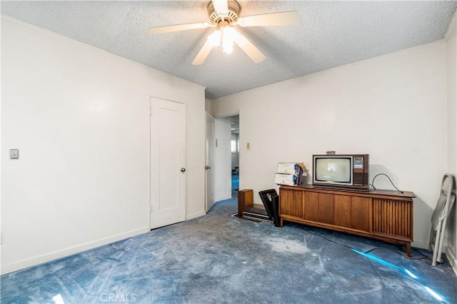interior space with carpet, a textured ceiling, baseboards, and ceiling fan