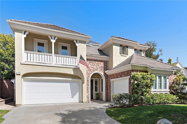 18 Beacon, Ladera Ranch, CA 92694 - view of front of property featuring stone siding, stucco siding, driveway, a balcony, and a garage