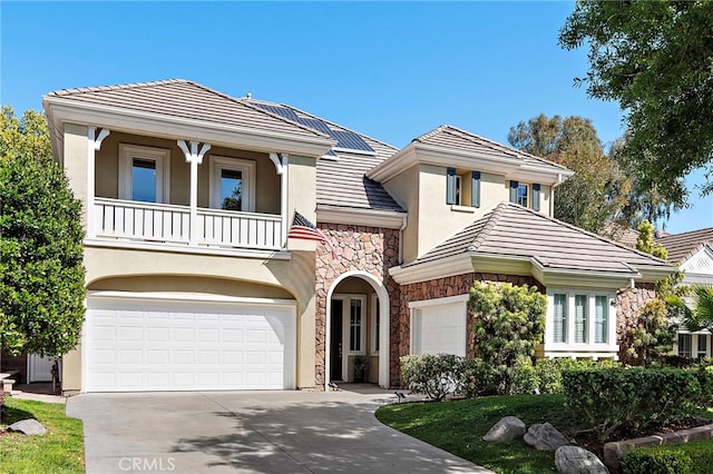 18 Beacon, Ladera Ranch, CA 92694 - view of front facade with stone siding, stucco siding, a balcony, driveway, and a tile roof