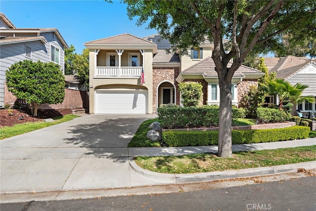 18 Beacon, Ladera Ranch, CA 92694 - view of front of property featuring a balcony, concrete driveway, a garage, stone siding, and stucco siding