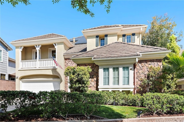 18 Beacon, Ladera Ranch, CA 92694 - view of front of house with stone siding, a balcony, stucco siding, a tile roof, and an attached garage