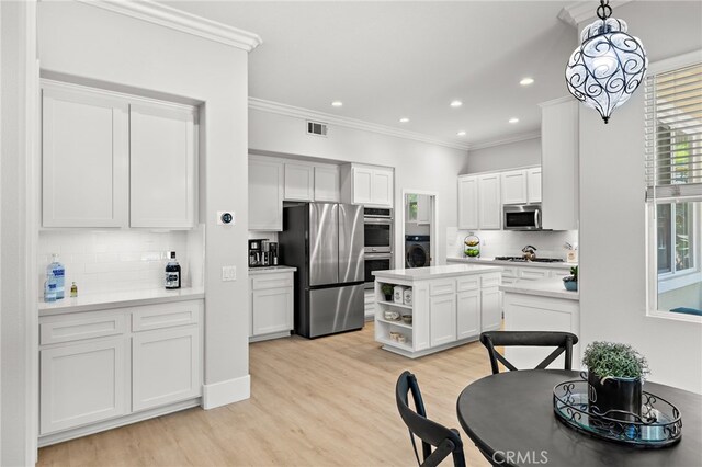 18 Beacon, Ladera Ranch, CA 92694 - kitchen featuring stainless steel appliances, washer / clothes dryer, decorative backsplash, white cabinetry, and crown molding