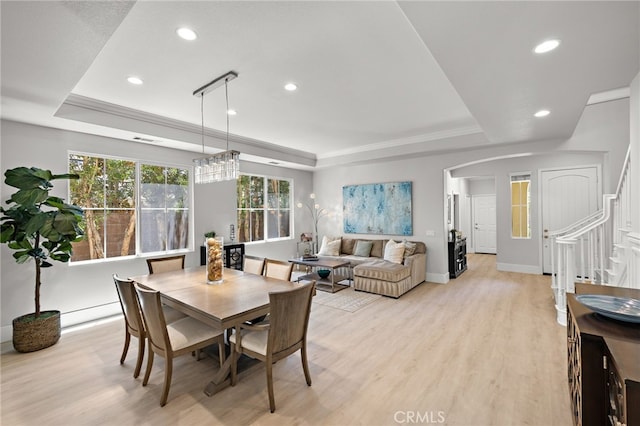 18 Beacon, Ladera Ranch, CA 92694 - dining space featuring a tray ceiling, light wood-style floors, recessed lighting, stairs, and arched walkways