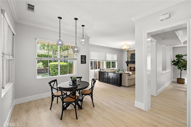 18 Beacon, Ladera Ranch, CA 92694 - dining area with light wood-style floors, a stone fireplace, and crown molding