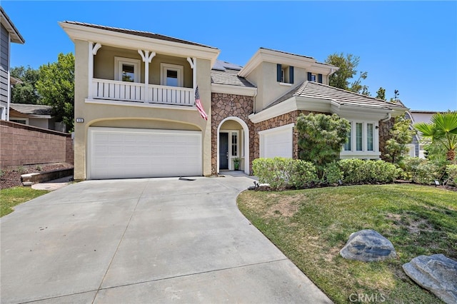 18 Beacon, Ladera Ranch, CA 92694 - view of front facade with a balcony, stucco siding, driveway, stone siding, and a garage