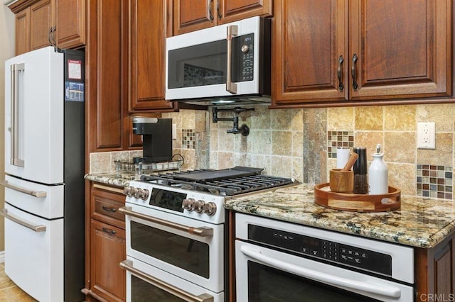 1034 Via Reata, Vista, CA 92081 - kitchen featuring light stone countertops, decorative backsplash, white appliances, and brown cabinetry