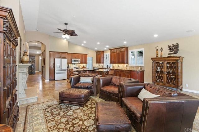 1034 Via Reata, Vista, CA 92081 - living room featuring recessed lighting, lofted ceiling, stone tile floors, arched walkways, and ceiling fan