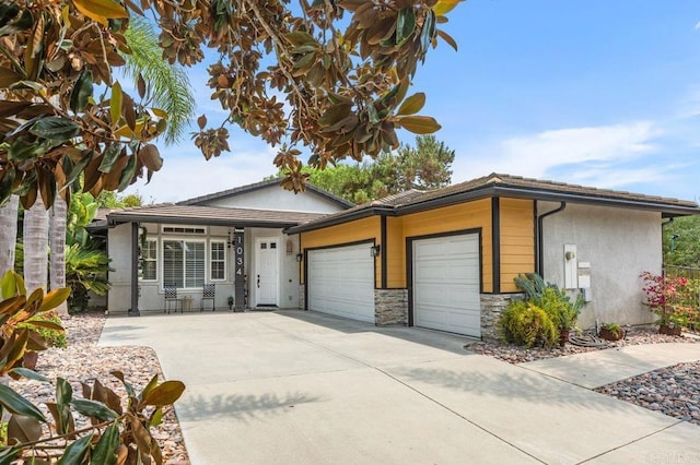 1034 Via Reata, Vista, CA 92081 - ranch-style house featuring an attached garage, driveway, stone siding, and stucco siding