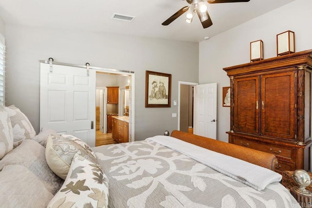 1034 Via Reata, Vista, CA 92081 - bedroom with a barn door, vaulted ceiling, visible vents, ensuite bathroom, and a ceiling fan