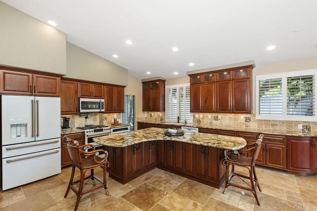 1034 Via Reata, Vista, CA 92081 - kitchen featuring a sink, premium appliances, decorative backsplash, glass insert cabinets, and a kitchen island