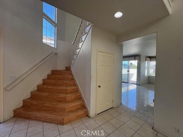 stairway with tile patterned floors, baseboards, and recessed lighting
