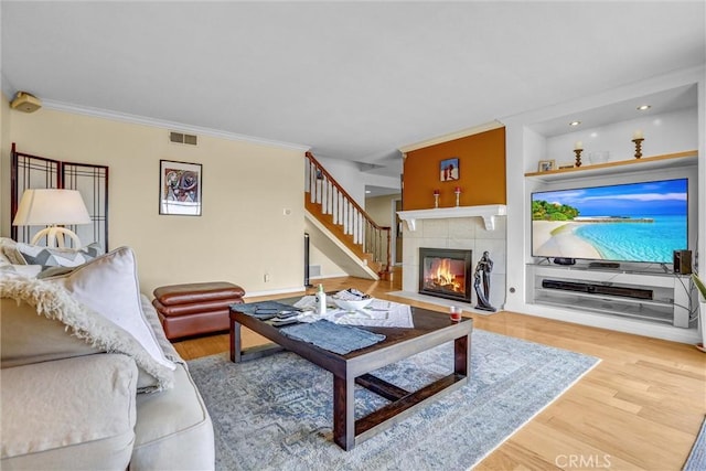 4612 Wolfe Way, Woodland Hills, CA 91364 - living room with wood finished floors, stairway, ornamental molding, a tile fireplace, and recessed lighting