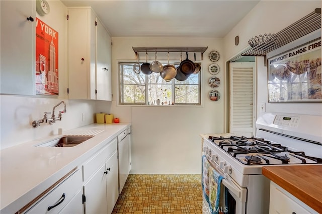kitchen featuring white cabinetry, a sink, and white appliances