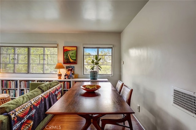 dining space with wood finished floors, baseboards, and visible vents
