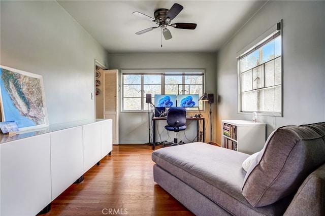 living area with wood finished floors and ceiling fan