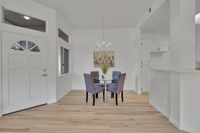 dining space featuring light wood-style flooring, baseboards, a notable chandelier, and visible vents