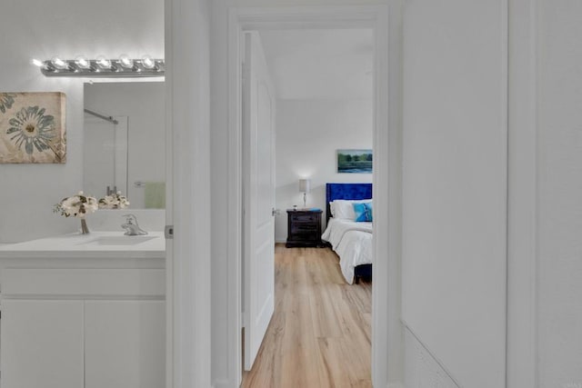 interior space with walk in shower, ensuite bath, wood finished floors, and vanity