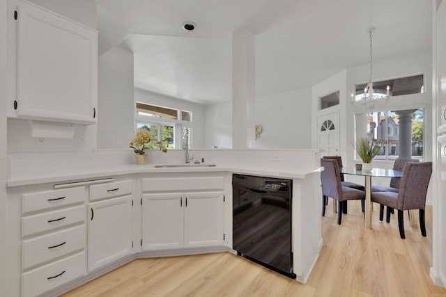 kitchen with white cabinets, an inviting chandelier, black dishwasher, a sink, and light wood-style flooring