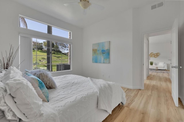 bedroom with light wood-style floors, visible vents, baseboards, and a ceiling fan