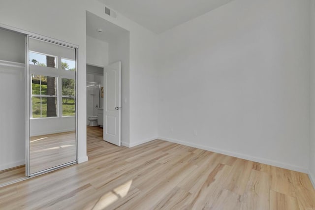 unfurnished bedroom featuring visible vents, baseboards, and wood finished floors