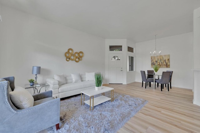 living room featuring baseboards, an inviting chandelier, and wood finished floors