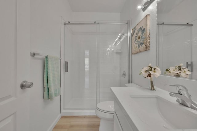 full bathroom featuring toilet, a shower stall, vanity, and wood finished floors