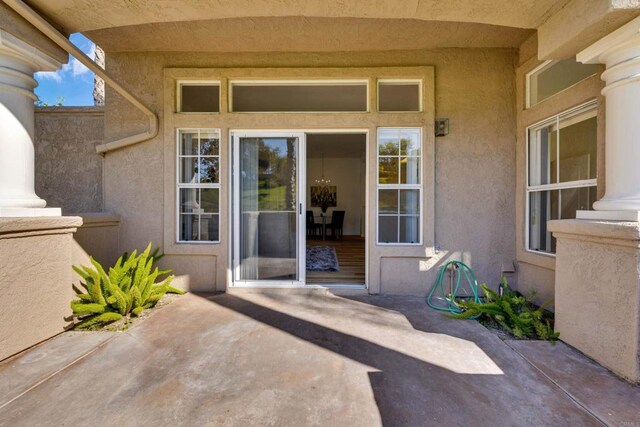 doorway to property featuring a patio and stucco siding
