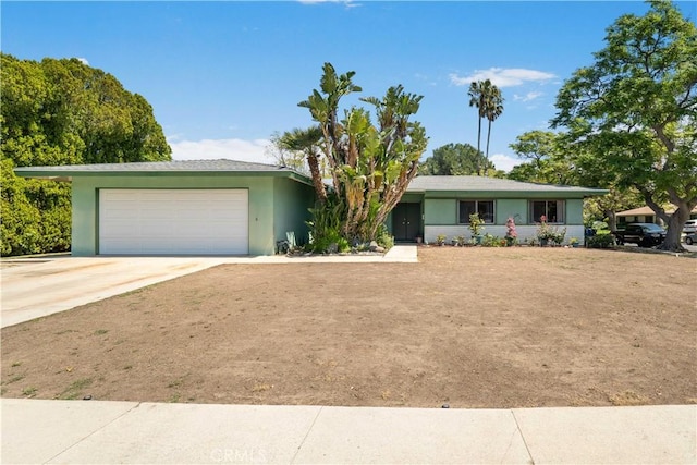 ranch-style home with concrete driveway, stucco siding, and a garage