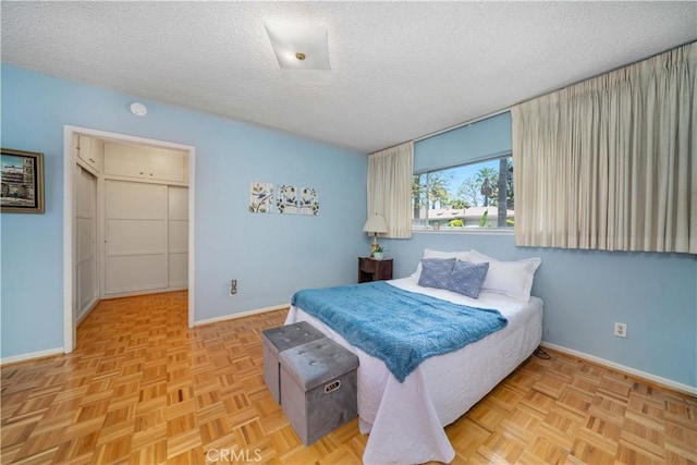 bedroom featuring a textured ceiling and baseboards