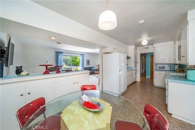 kitchen featuring tile countertops, visible vents, white cabinets, and white appliances